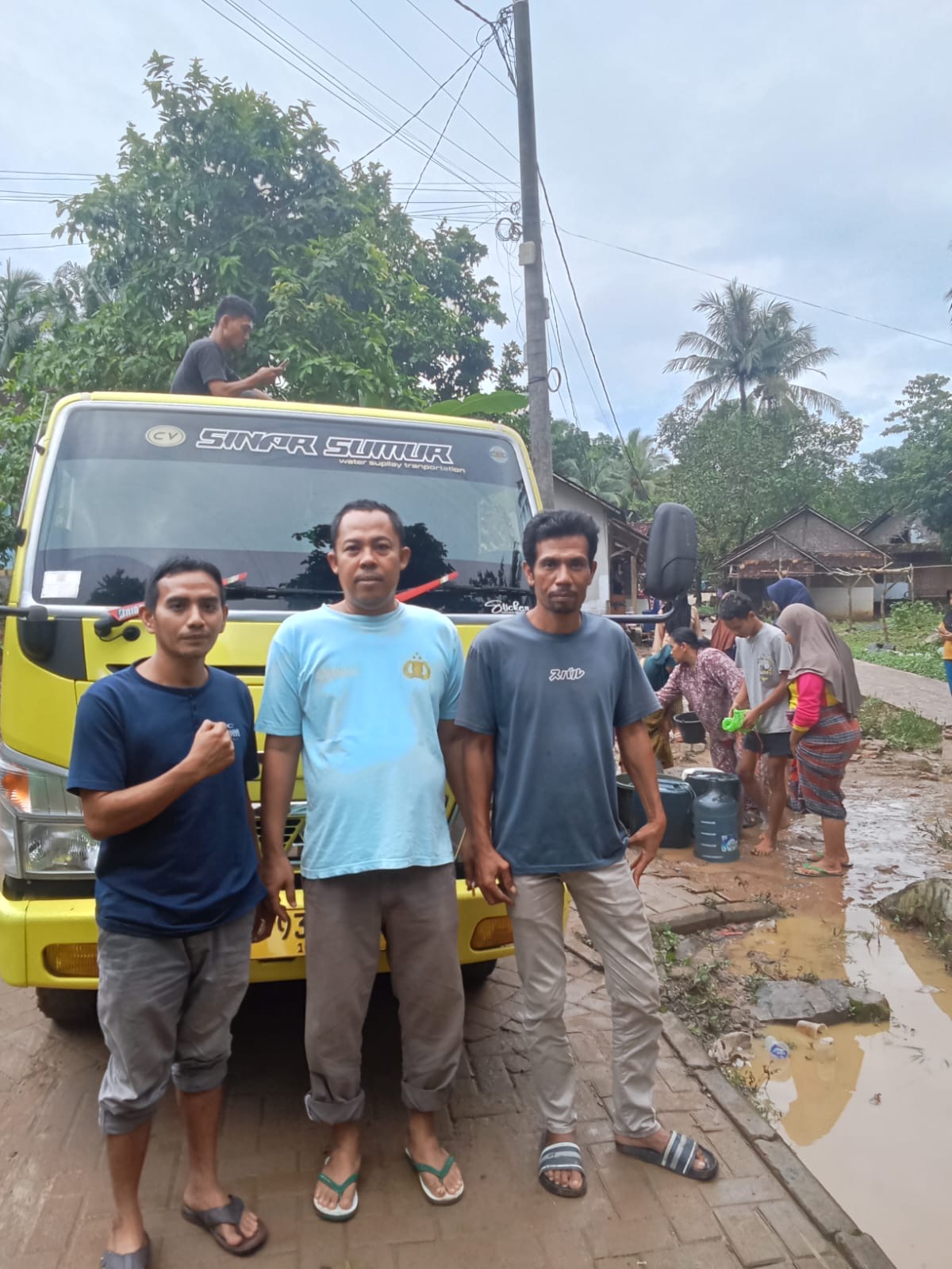 AIPTU AHMAD DIMYATI ANGGOTA POLSEK SUMUR &RUMAH YATIM BERIKAN BANTUAN AIR BERSIH KEPADA WARGA TERDAMPAK BANJIR